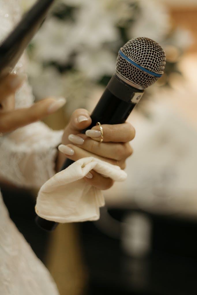 Bride holding a microphone during her wedding speech, symbolizing love and celebration.